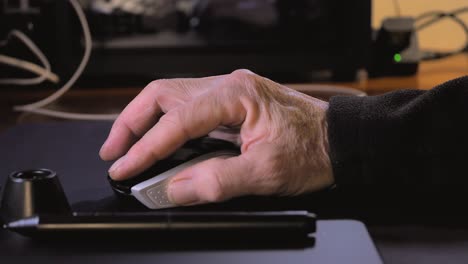 Die-Hand-Eines-älteren-Mannes,-Der-Zu-Hause-Eine-Computermaus-Auf-Einem-Tisch-Verwendet