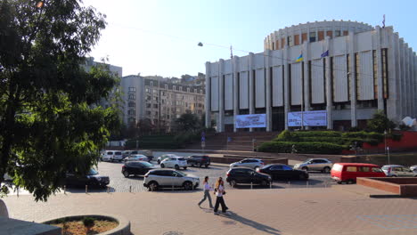Khreshchatyk-main-street-of-Kyiv-city-center-in-Ukraine,-people-walking,-sunny-weather-and-cars-driving-on-a-road,-4K-shot