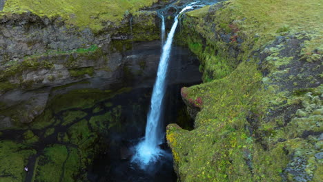 Aerial-View-Of-Kvernufoss-Waterfall,-Thundering-Falls-Flowing-Through-Moss-covered-Cliffs-In-Iceland