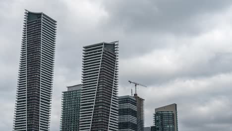 Nubes-Sobre-Rascacielos-Y-Construcción-En-Toronto,-Inclinar-Hacia-Arriba-El-Timelapse