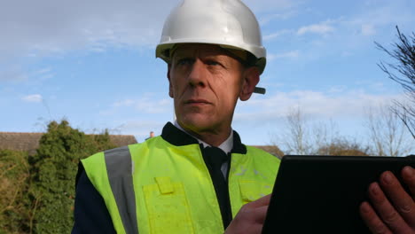 Portrait-of-an-architect-construction-building-inspector-using-a-tablet-on-a-building-site-on-a-residential-street