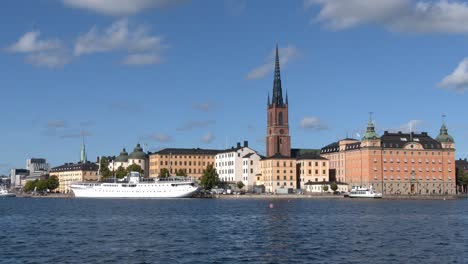 Stockholm-old-town-general-view-including-some-ships,-the-harbour-and-the-Riddarholmen-Church-tower