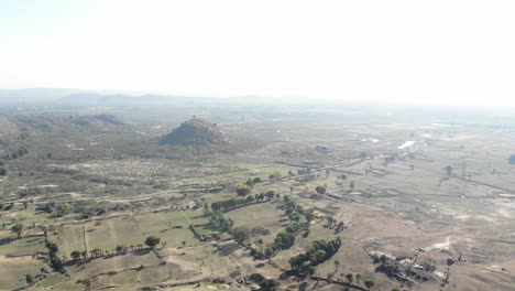 Toma-Aérea-Giratoria-De-Tierras-áridas-Y-áridas-Con-Carretera-Asfaltada-En-Huntergunj,-Jharkhand,-India.