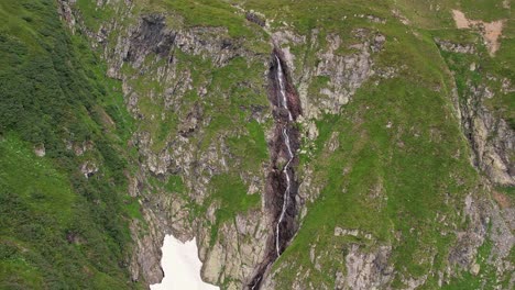 The-valea-rea-waterfall-cascading-down-fagaras-mountains,-lush-greenery-surrounding,-aerial-view