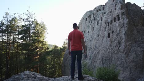 Touristen-Stehen-Vor-Einer-Natürlichen-Felsformation-Und-Einem-Opferaltar-Namens-Adlerfelsen,-Oder-Besser-Bekannt-Als-Orlovi-Skali,-Im-Rhodopengebirge-In-Bulgarien