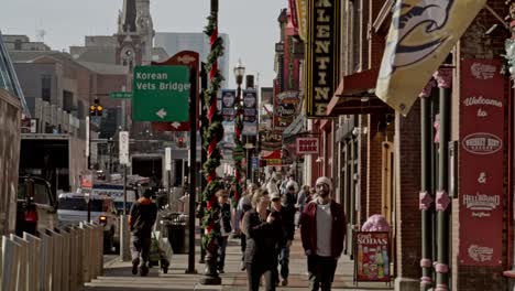 Tourists-on-Broadway-Street-in-Nashville,-Tennessee-during-the-day-with-wide-shot-stable-video-in-slow-motion