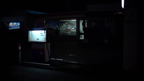 Eine-Tankstelle-Mitten-In-Der-Nacht,-Mit-Einem-Flackerndem-Licht-Auf-Der-Rechten-Seite