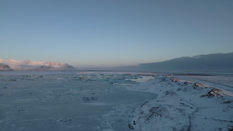 Volando-Sobre-Tierras-Vacías-Congeladas,-Campos-Nevados-Durante-La-Puesta-De-Sol,-Sur-De-Islandia