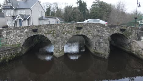 Coche-Conduciendo-A-Través-Del-Puente-De-Piedra-En-Arco-En-Ballinodre,-Monaghan,-Irlanda