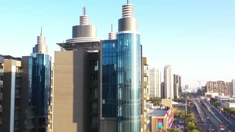 AERIAL-DRONE-VIEW-Dawn-camera-moving-up-from-below-where-a-large-high-rise-building-is-visible