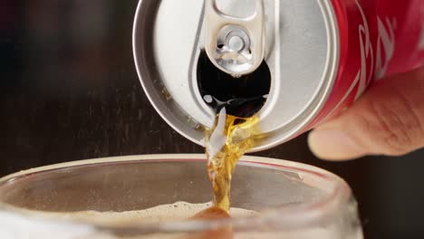 Close-up-of-Coca-Cola-being-poured-from-can-into-glass-with-ice,-slomo