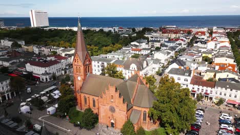 church-in-small-town-by-the-sea,-blue-sea-in-the-background,-baltic-sea,-warnemünde,-drone