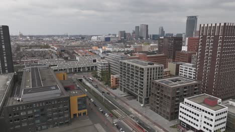Forward-droneshot-of-The-Hague-railway-station-and-city-centre,-train-leaving