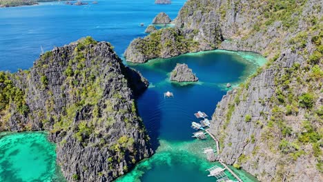 Drohnenaufnahmen-über-Einer-Lagune-Mit-Booten-Auf-Der-Insel-Coron-Auf-Den-Philippinen