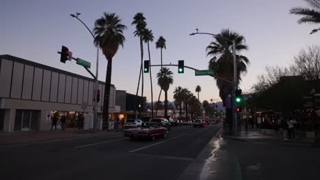 Zeitraffervideo-Der-Innenstadt-Von-Palm-Springs,-Kalifornien,-In-Der-Abenddämmerung-Mit-Fahrzeugen-Und-Fußgängern