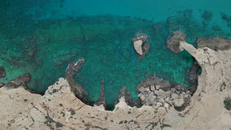 Aerial-view-of-turquoise-sea-waters-and-rocky-coastline