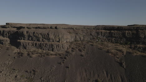 AERIAL-DRONE-SHOT-OF-SUN-LAKE-DRY-FALLS-CLIFF-SIDE-MOVING-SIDEWAYS