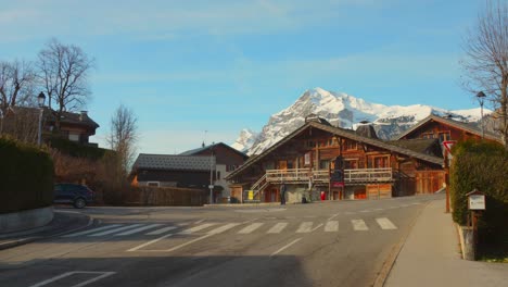 Alpine-village-Les-Carroz-d'Arâches-with-snow-capped-mountains-in-the-backdrop,-clear-blue-sky,-during-daytime,-tranquil