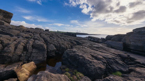 Panorama-motion-timelapse-of-rugged-rocky-coastline-on-sunny-cloudy-day-with-Classiebawn-castle-in-distance-in-Mullaghmore-Head-in-county-Sligo-on-the-Wild-Atlantic-Way-in-Ireland