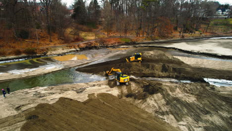 Aerial-dolly-of-yellow-excavator-and-bulldozer-transferring-sedimentation-at-freshwater-diversion-pond