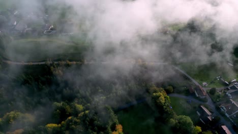 Aerial,-sky-is-covered-in-a-thick-layer-of-fog,-creating-a-moody-and-mysterious-atmosphere