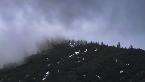 Dramatische-Wolkendecke,-Die-Sich-Schnell-über-Die-Schneebedeckten-Kiefernwälder-Des-Frazier-Parks-Im-Süden-Kaliforniens-Bewegt,-Teleaufnahme-Aus-Der-Luft,-60 fps
