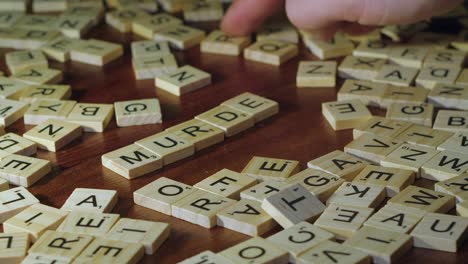 Narrow-focus-closeup:-Letter-tiles-form-word-MURDER-in-Scrabble-game