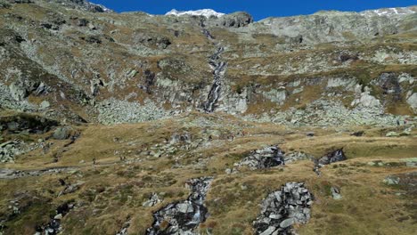 People-Hike-Olpererhutte-Trail-through-Mountain-Landscape-in-Zillertal-Alps,-Austria---Aerial-4k