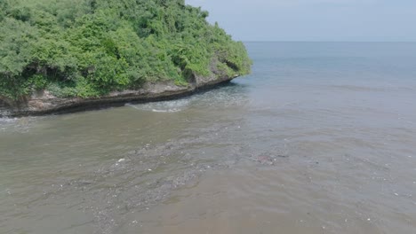 Luftaufnahme-Einer-Drohne-In-Geringer-Höhe-über-Verschmutztem,-Schlammigem-Abwasser-Und-Schwimmendem-Müll-Mit-Schutt-über-Einem-Abgestorbenen-Korallenriff,-Vermischt-Mit-Türkisfarbenem-Wasser-Und-Tropischer-Küste-In-Bali,-Indonesien