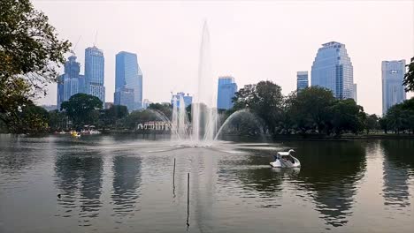 Sunrise-over-Lumpini-Park,-Bangkok,-with-skyline-and-lake,-peaceful-morning,-Amazing-Thailand