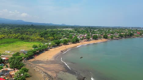 Aerial-circular-view-of-Melao-beach,-a-beach-known-for-being-a-large-fishing-village-in-Sao-Tome,Africa