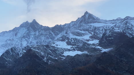 Alpes-Suizos-Otoño-Primero-Nieve-Polvo-Picos-De-Las-Montañas-Saas-Fee-Zermatt-Saastal-Valle-Alpino-Chalet-Estación-De-Esquí-Ciudad-Atardecer-Amarillo-Rosas-Nubes-Altas-Suiza-Europa-Cinematográfico-Panorámica-Revelar
