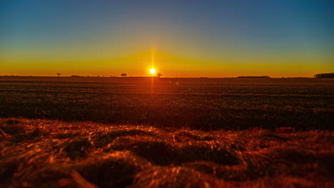 Golden-sunset-dusk-across-countryside-farmland-fields---nightfall-time-lapse