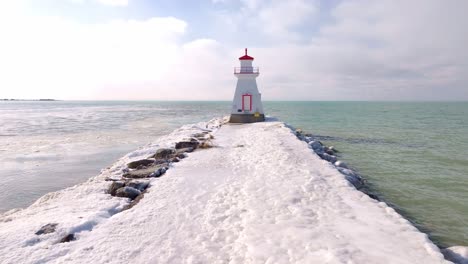 Winter-scene-of-a-snowy-pier-leading-to-the-Southampton-lighthouse-under-a-cloudy-sky