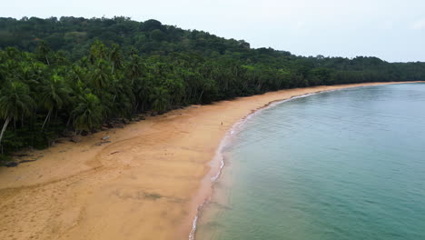 Drone-Rodeando-A-Una-Chica-Caminando-Por-La-Playa-Praia-Grande-En-Ilha-Do-Príncipe,-África