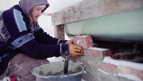 The-Man-is-Double-checking-that-the-Bricks-Fit-Before-Cementing-them-Beneath-the-DIY-Hot-Tub---Close-Up