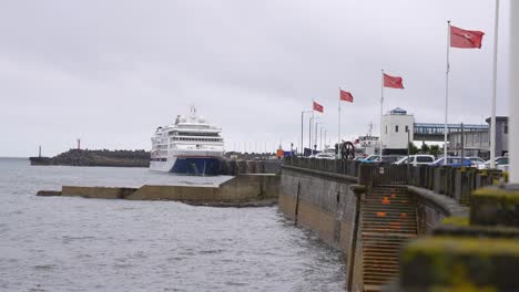 Douglas,-Isle-Of-Man,-Kreuzfahrtschiff-Im-Hafen-Und-Nationalflaggen-Auf-Der-Promenade,-Weite-Sicht,-Zeitlupe