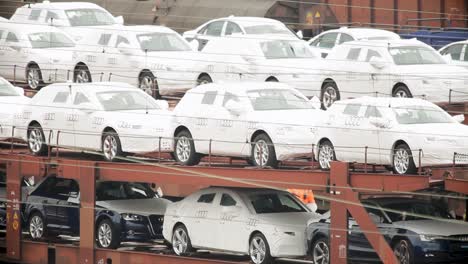 Neue-Audi-Autos-Verpackt-Für-Die-Auslieferung-Auf-Güterzug,-Bewölkter-Tag,-Fokus-Auf-Automobilindustrie