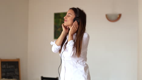 slow-motion-of-caucasian-young-sexy-woman-dancing-alone-while-listening-music-with-headphone-at-home