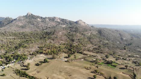 Aerial-shot-of-small-mountain-range-and-forest-in-Jharkhand,-India-in-summer