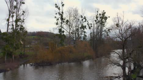 Bewölkter-Tag-Mit-Blick-Auf-Den-Fluss-Clécy-In-Der-Normandie,-Frankreich-Mit-Hohen-Bäumen-Und-Reflexion