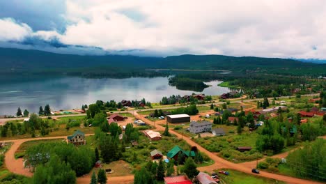 Luftaufnahme-Einer-Kleinen-Bergstadt-Neben-Dem-Grand-Lake-In-Colorado-Mit-Hügeln-Und-Wolken-Per-Drohne