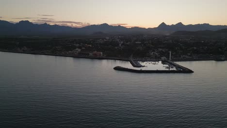 Paisaje-De-Drones-Al-Atardecer-En-La-Bahía-Marina-De-Loreto-Baja-California-Horizonte-Aéreo-Mexicano-Al-Atardecer-A-Lo-Largo-De-La-Cordillera,-Colores-Del-Horizonte-De-La-Hora-Dorada