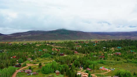 Aerial-Drone-View-of-Mountain-Village-in-Summer-Surrounded-by-Pine-Tree-Forest-and-Rolling-Hills-in-the-Rocky-Mountains-on-a-Cloudy-Day