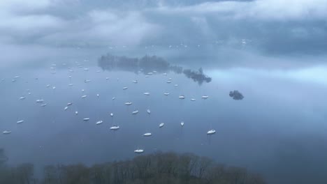 Zurückweichende-Drohnenaufnahme-Des-Windermere-Sees,-Die-Die-Segelboote-Zeigt,-Die-In-Den-Gewässern-Des-Lake-District-In-Cumbria-In-England-Segeln-Und-Schwimmen