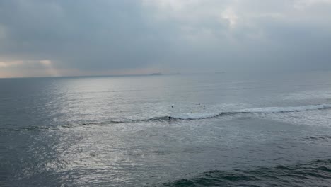 Surfistas-Montando-Olas-Del-Océano:-Una-Escena-Espectacular-Con-Un-Cielo-Nublado-Que-Añade-Dramatismo-A-La-Aventura-Del-Surf