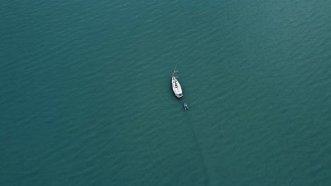 Aerial-footage-of-a-sail-boat-in-blue-water