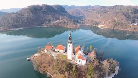 Forward-drone-shot-of-Bled-Church-situated-between-Bled-Lake-in-Slovenia