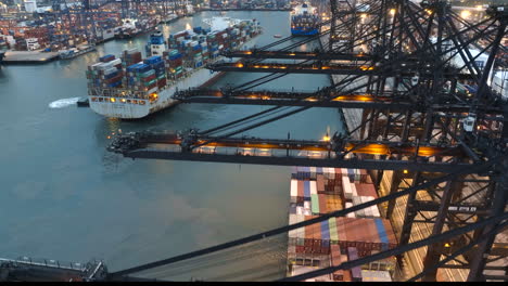 Close-up-lifiting-view-of-gantry-cranes-in-Hong-Kong-port-while-a-Cosco-container-vessel-gets-berthed--wide-angle-anamorphic-look