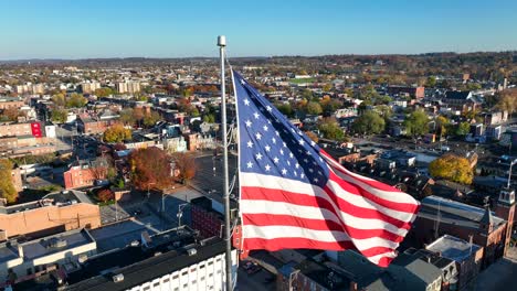 American-flag-waving-over-small-town-in-autumn